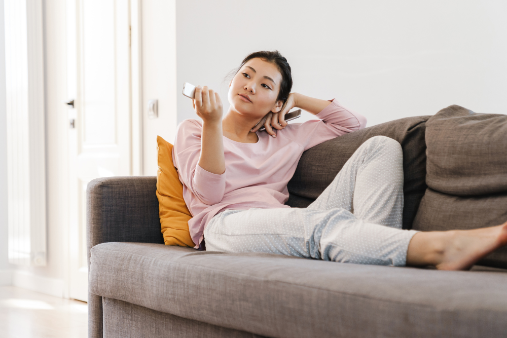 a woman on a coach in coliving studio A woman in a studio apartment in coliving